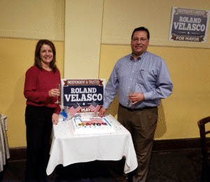 Photo by Char Marrazzo Roland Velasco celebrates becoming the mayor of Gilroy by cutting a cake with his wife, Lisa Velasco, at the Old City Hall restaurant on election night.
